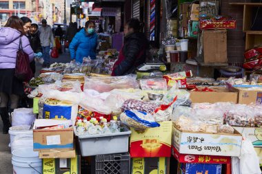 New York (United States), March 3, 2024. Seller on the street in Chinatown. In New York's Chinatown there are many street stalls selling all kinds of products, fish, seafood, legumes, fruits, etc. clipart
