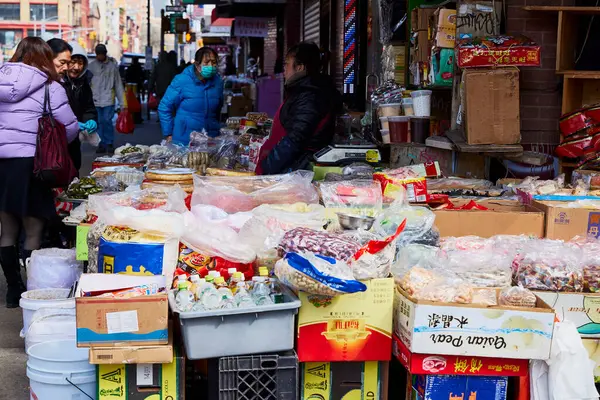 stock image New York (United States), March 3, 2024. Seller on the street in Chinatown. In New York's Chinatown there are many street stalls selling all kinds of products, fish, seafood, legumes, fruits, etc.