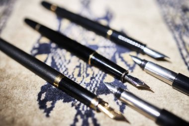 Fountain pens. Various fountain pens from different periods on a mat clipart