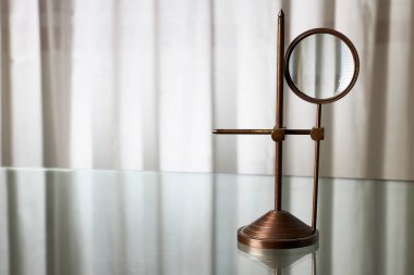 Büyüteç. Cam yüzeyde dönen eski bir büyüteç.