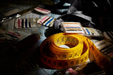 Dikiş dikiyorum Masadaki şerit, düğme, makas, iplik ve iğneleri ölçmek