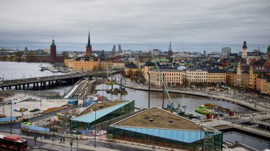 İnşaat. Stockholm (İsveç), 19 Nisan 2025. İsveç başkentinin genel görüşü. Ön planda, demiryolu hattını kapamak için inşaat çalışmaları yapılıyor..