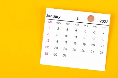 Ocak 2023 ve sarı arkaplanda tahta raptiye.