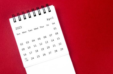 Nisan 2023 Aylık masa takvimi kırmızı zemin üzerinde 2023 yılı için.