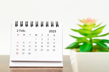 2023 Şubat ayının masa takvimi ahşap masa üzerinde küçük bir bitki ile 2023 yılı.