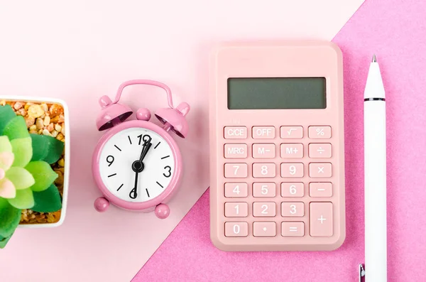 ピンクの背景にペンとトップビューピンクの電卓と目覚まし時計 — ストック写真