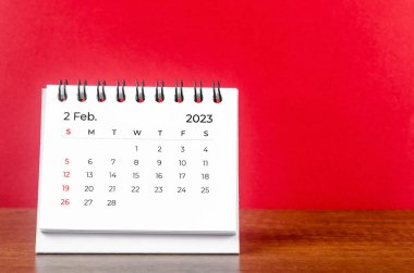 February 2023 desk calendar for 2023 year on Red color background. clipart
