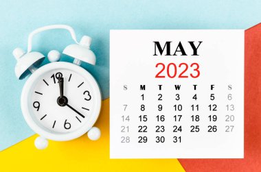 Mayıs 2023 Aylık takvim yılı ve renkli arkaplanda alarm saati.