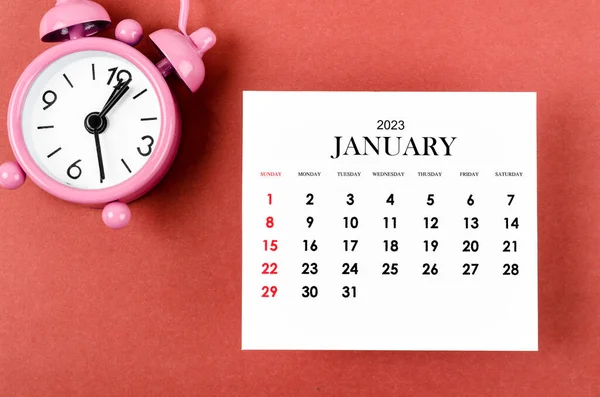 stock image January 2023 Monthly calendar year for 2023 year with alarm clock on red background.