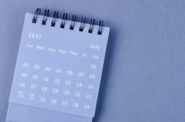 July 2023 Monthly desk calendar for 2023 year on blue background. clipart