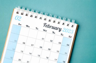 Mavi arkaplan üzerinde planlama ve hatırlatma için Şubat 2023 takvim masası.