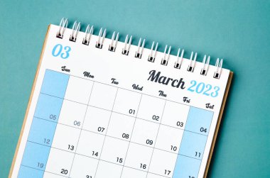 Organizatörün mavi arkaplanda izole edilip hatırlatılması için Mart 2023 takvim masası.