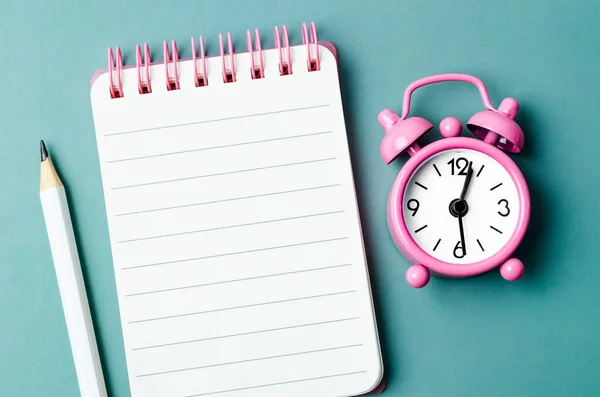 空のオープン日記と青い色の背景に鉛筆で目覚まし時計 — ストック写真