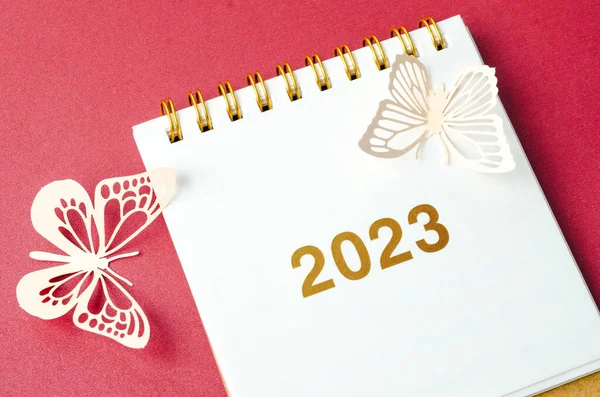 2023年桌上日历和红色背景的纸蝴蝶 — 图库照片
