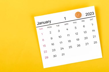 Ocak 2023 ve sarı arkaplanda tahta raptiye.