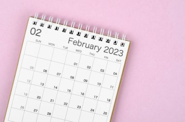 Pembe arka planda, organizatörün planlayıp hatırlatması için Şubat 2023 takvim masası.