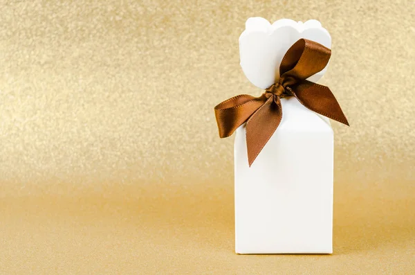 金光闪闪的圣诞背景上有褐色缎带的礼品盒 — 图库照片
