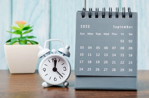 2023年9月木製の背景に目覚まし時計と2023年の毎月の机のカレンダー — ストック写真