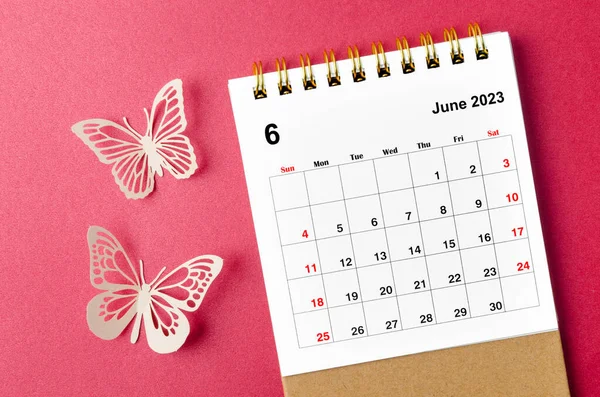 June 2023 calendar desk for the organizer to plan and reminder with butterfly paer on red background.