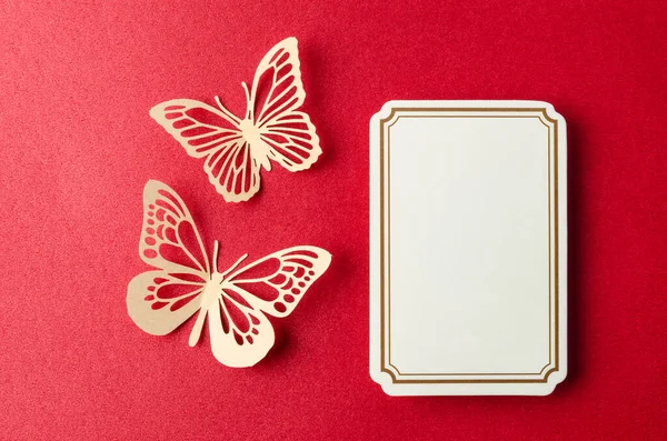 Blank notes adhesives paper for your text or message and paper butterfly on red background.