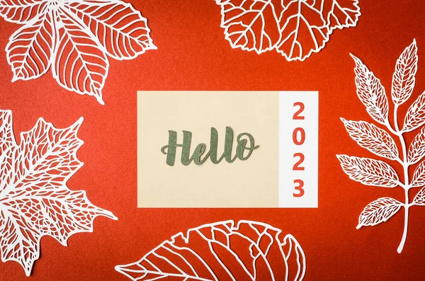Hello 2023テキスト上のメモ用紙と赤の背景の紙の葉 — ストック写真