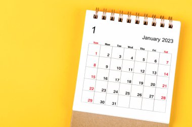 2023 yılı Ocak ayının masa takvimi sarı arka planda..