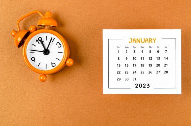 2023 Ocak 'ında, organizatörün sarı zemin üzerindeki alarm saatiyle 2023 yılını planlaması için aylık takvim..
