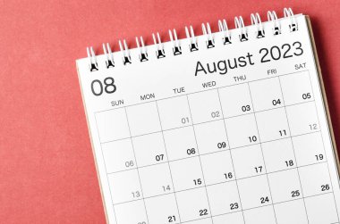 Kırmızı arkaplanda, organizatörün planlaması ve hatırlatması için Ağustos 2023 takvim masası.