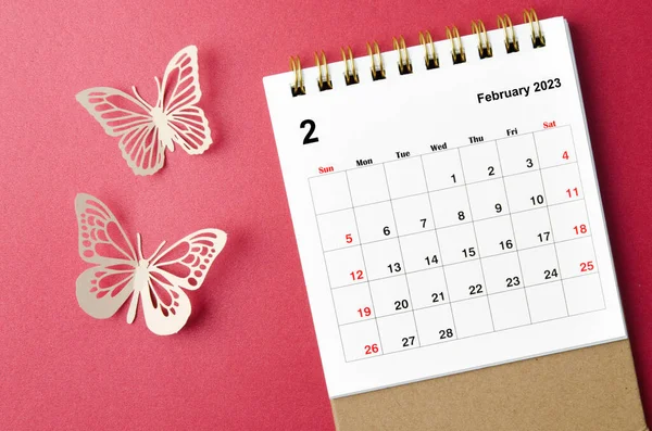 February 2023 calendar desk for the organizer to plan and reminder with butterfly paer on red background.