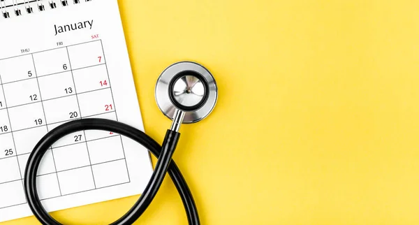 Stethoscope medical and calendar with empty space on the yellow background, schedule to check up healthy concepts.