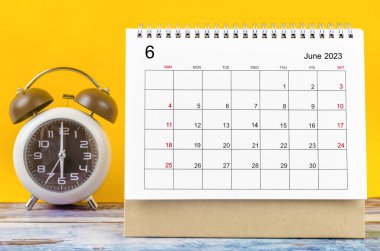 June 2023 Monthly desk calendar for 2023 year and alarm clock.
