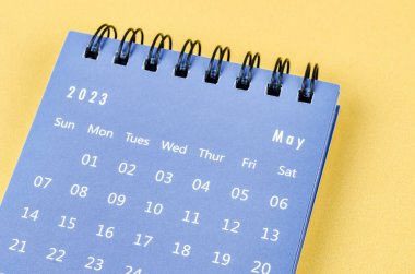 2023 Mayıs ayının masa takvimi sarı arka planda..
