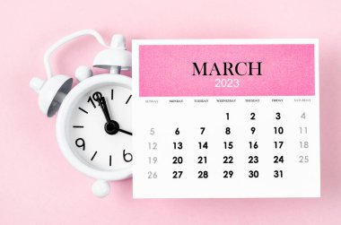 March 2023 Monthly calendar year with alarm clock on pink colour background.