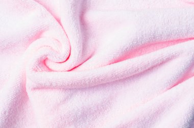Textured pink colour natural cotton towel background photo with selective focus.