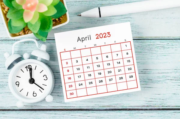 April 2023 Månadskalender Och Väckarklocka Med Penna Blå Trä Bakgrund — Stockfoto