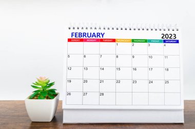 2023 Şubat ayının masa takvimi ahşap masa üzerinde küçük bir bitki ile 2023 yılı.