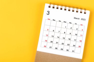 2023 Mart ayının masa takvimi sarı zemin üzerinde 2023 yıl için.