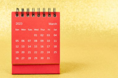 Red March 2023 Monthly desk calendar for 2023 year on golden color background.