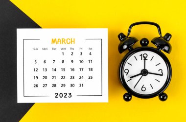 2023 Mart ayının takvimi. Güzel arka planda siyah alarm saati var..