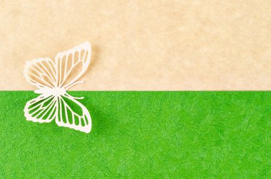 Butterfly made from carve paper or cutting on green and yellow background with empty space for your text or message.