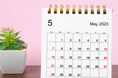 May 2023 Monthly desk calendar on wooden table.