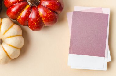 Blank reminder note and pumpkins on yellow background, space for text.