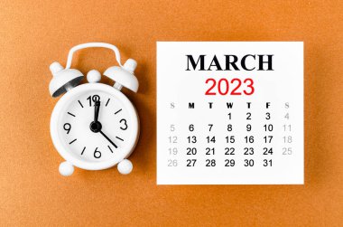 March 2023 Monthly calendar for the organizer to plan 2023 year with alarm clock on orange colour background.