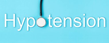 Hypotension text and medical stethoscope on blue background, Screening for Hypotension disease concepts.