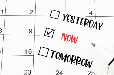 Yesterday, Now, Tomorrow choice and pen on calendar page background.
