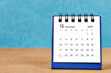 December 2023 desk calendar on blue color background.