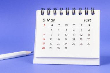 May 2023 Monthly desk calendar for 2023 year with pencil on purple background.