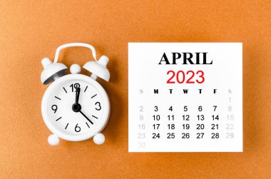 2023 Nisan 'ında, organizatörün sarı zemin üzerindeki alarm saatiyle 2023 yılını planlaması için aylık takvim..