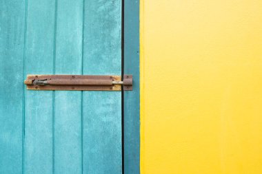Kapalı asma kilit sarı ve mavi duvarlarda asılı..