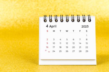 2023 Nisan ayının masa takvimi altın renkli arka planda 2023 yılı.